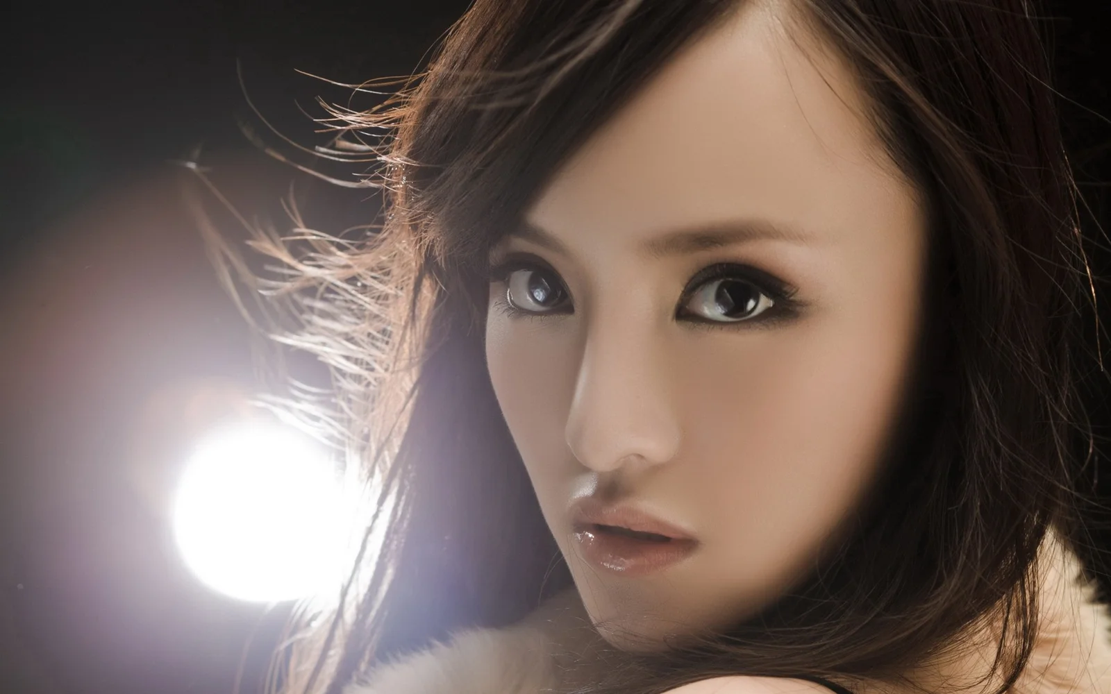 一位成年女性的面部特写，深色长发和柔和的侧面光线清晰可见。