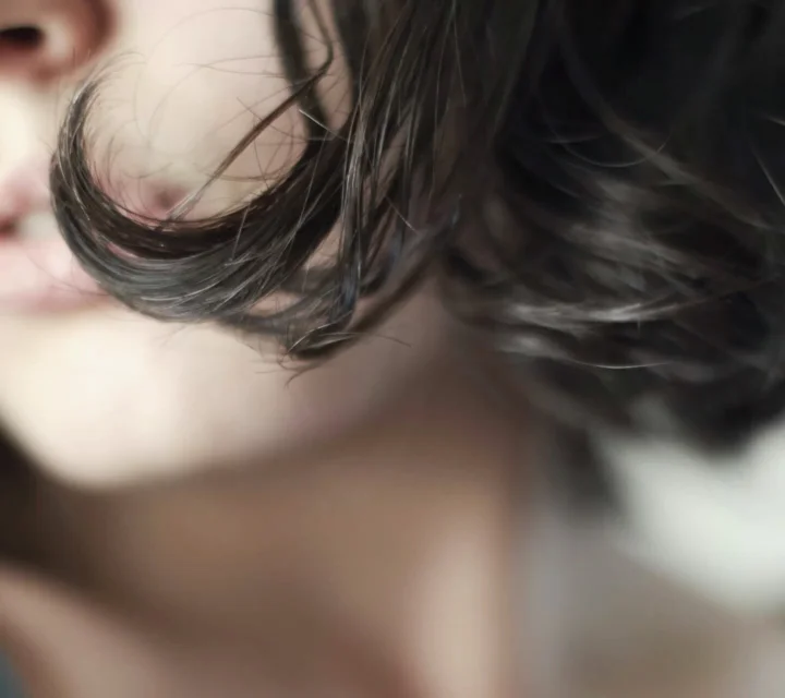 검은 머리 성인의 얼굴 일부와 머리카락, 목 부분을 가까이 담은 인물 사진입니다.