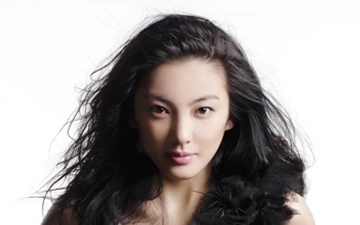 一位黑发女性在白色背景前面对镜头。