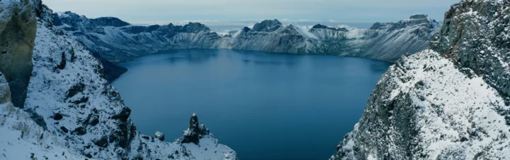积雪覆盖的山峰环绕着一片宁静的蓝色湖泊。