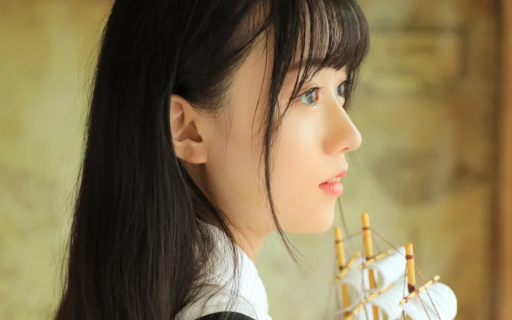一名长发女性面向右侧的侧脸肖像，背景柔和自然。