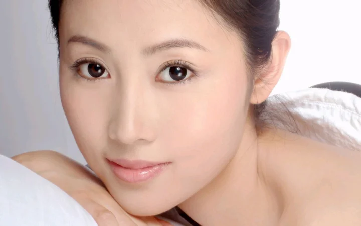 一位成年女性的近距离面部肖像，背景简洁明亮。