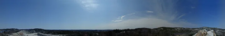蓝天下的山脉延伸在地平线上，构成宽幅全景风景。