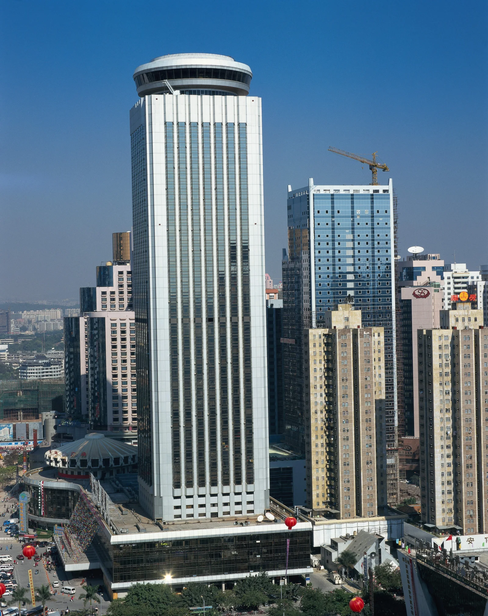 蓝天下，高耸的现代建筑群与城市街道构成一幅城市景观。