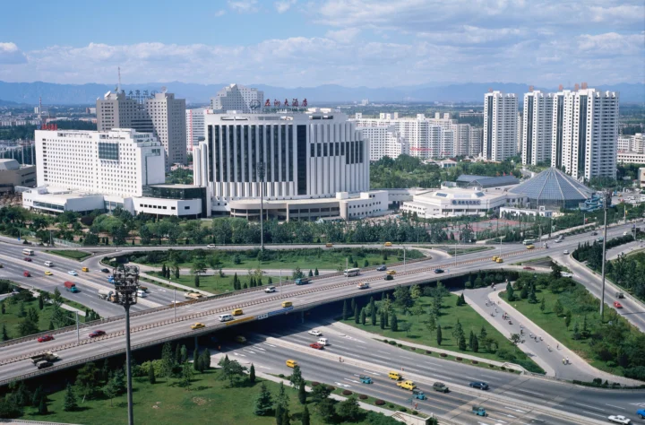 现代城市建筑群与多层立交道路在晴朗天空下展开。
