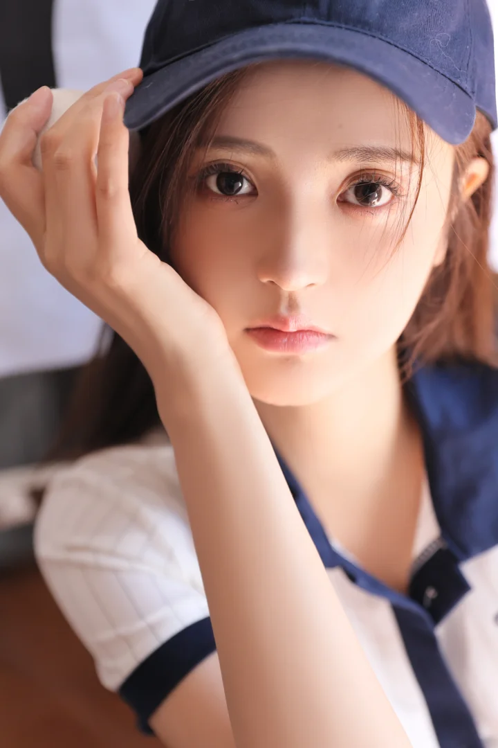 一名戴着深色帽子的女性以手托脸，近距离注视镜头。