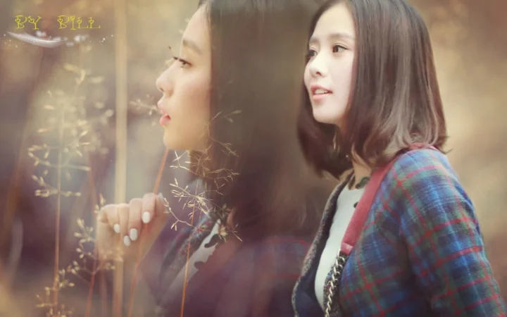 一名穿格纹上衣的女子站在窗边，玻璃映出她的侧脸，画面笼罩在柔和的暖色光线中。