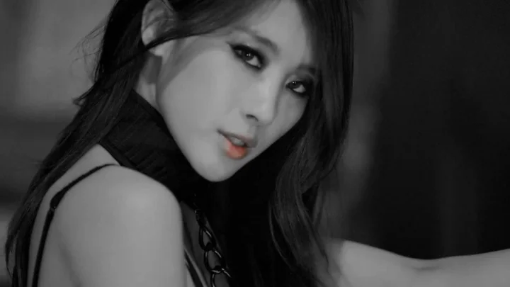 성인 여성이 카메라를 가까이 바라보며 입술 색상이 돋보이는 흑백 인물 사진입니다.