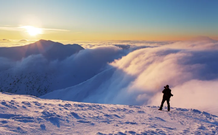 日出照亮积雪山脉与翻涌的云海。
