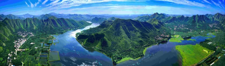 俯瞰群山、蜿蜒河流、湖泊与农田交织的壮丽全景。