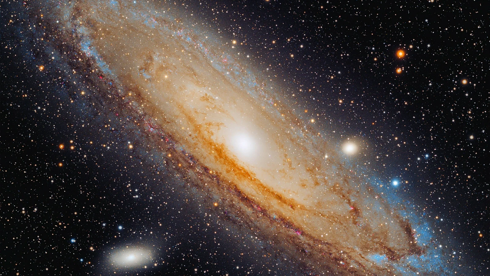 一幅旋涡星系横跨画面并被密集星空环绕的宇宙影像。