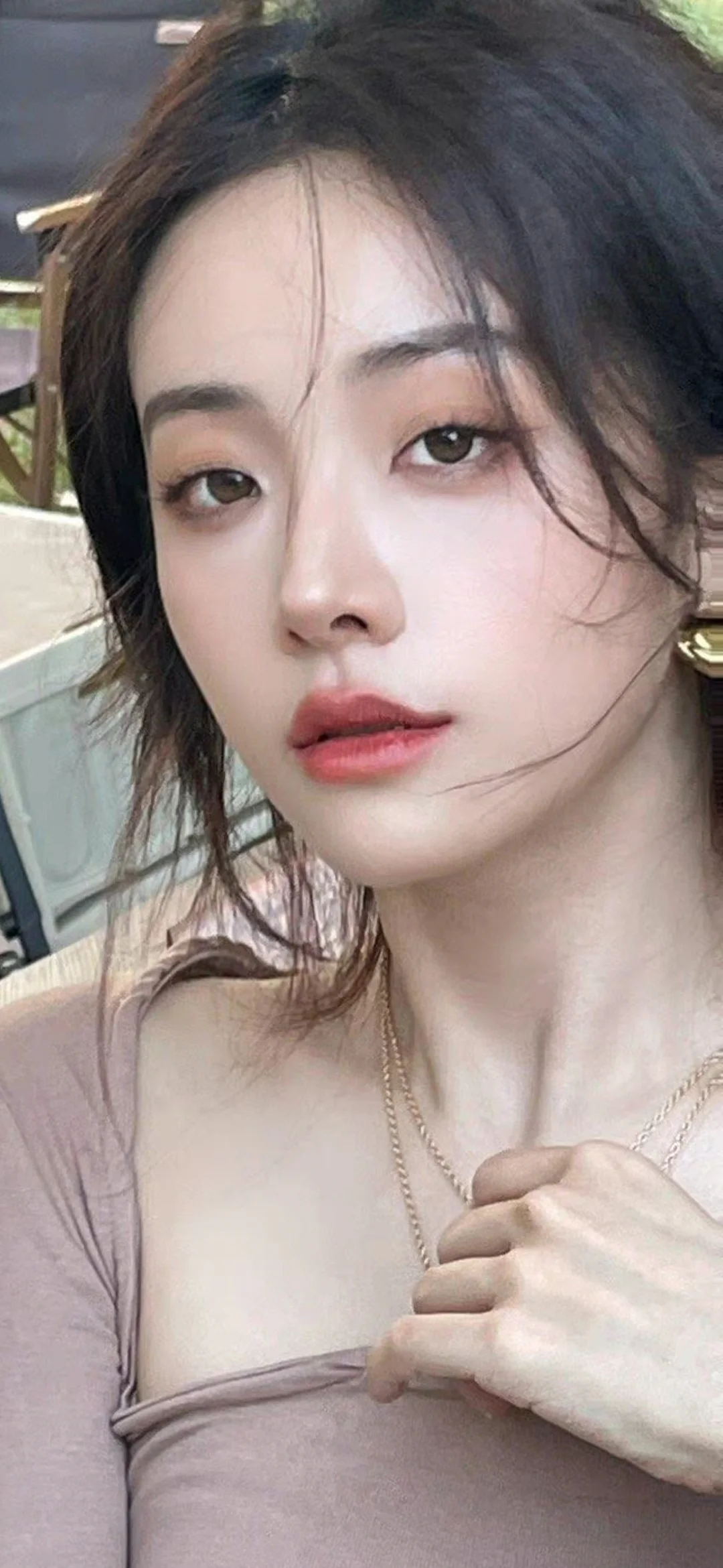 一位成年女性在户外环境中进行近距离自拍式肖像拍摄。