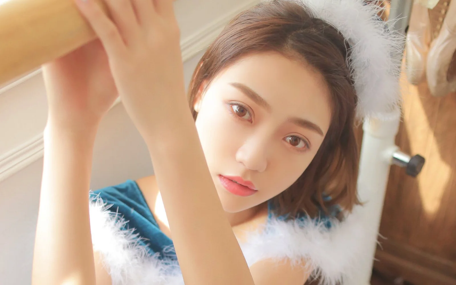 一位成年女性在室内靠近镜头凝视，柔和光线映照着她的面容。