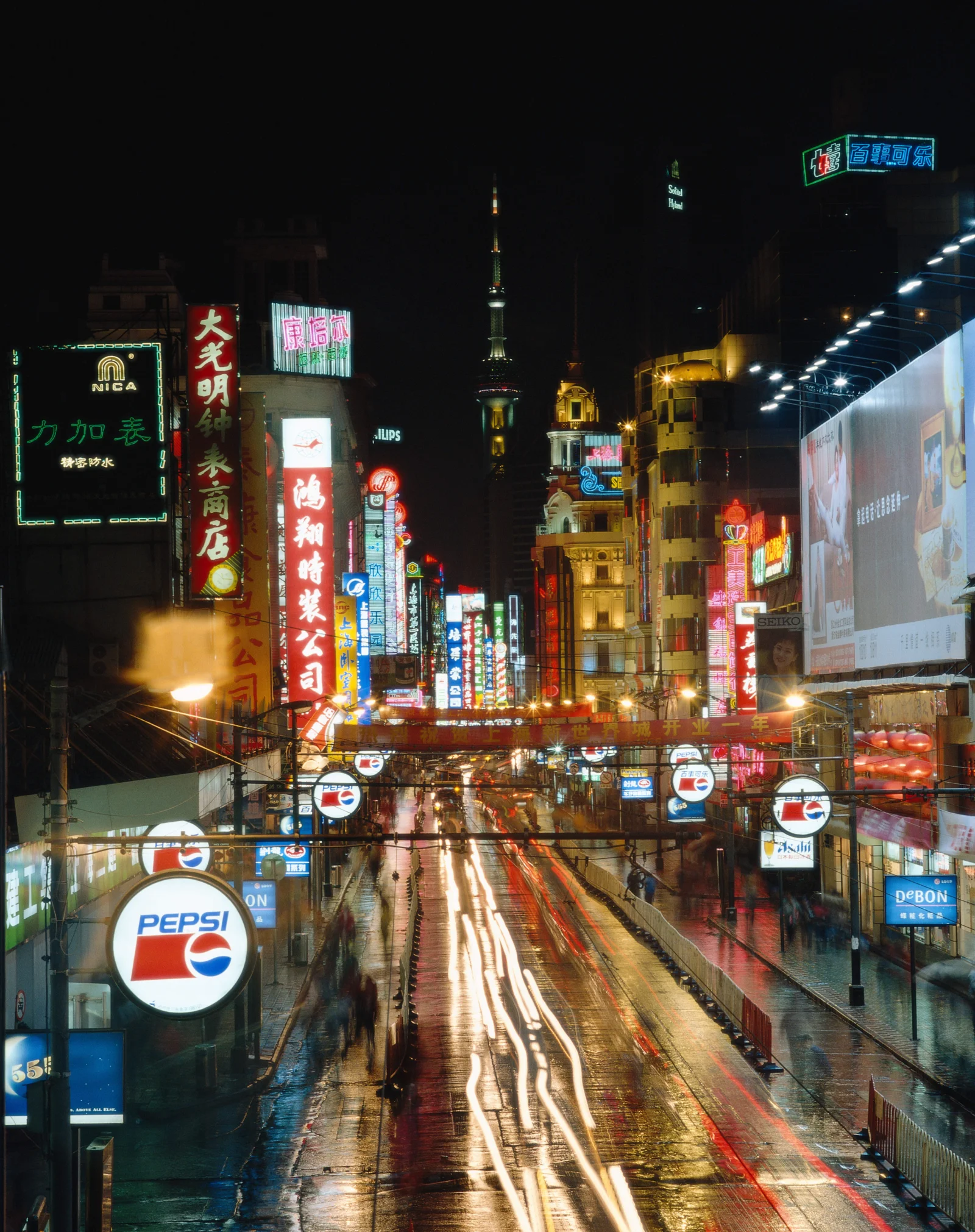 雨夜的城市街道两旁布满霓虹招牌，湿润路面倒映着绚丽灯光。