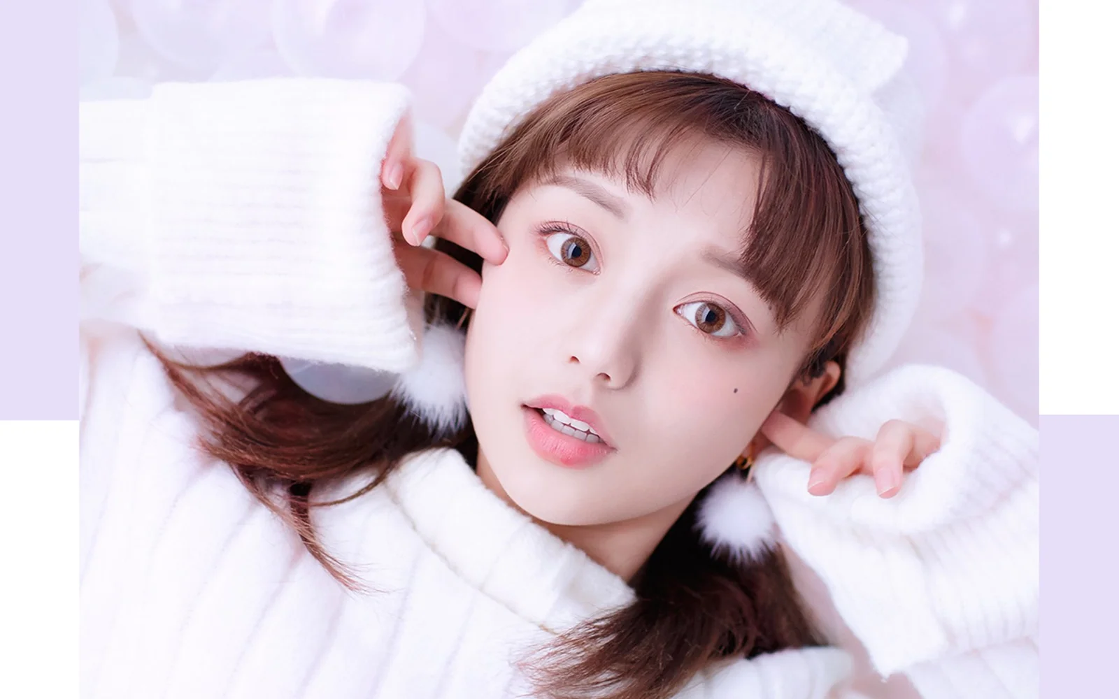 一位戴着白色针织帽、穿着白色毛衣的女性近距离面对镜头。