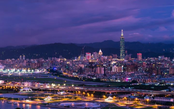 暮色中的城市灯光、摩天大楼与远山构成壮观的夜景天际线。