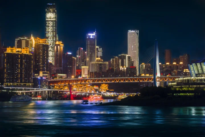 夜色中的重庆城市天际线、灯火通明的桥梁与江面倒影构成璀璨都市景观。