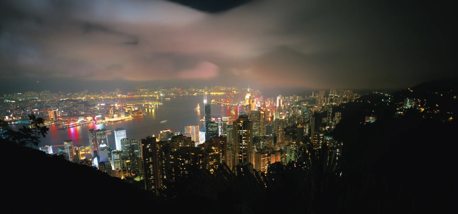 从高处俯瞰灯火璀璨的城市天际线与港湾夜景。