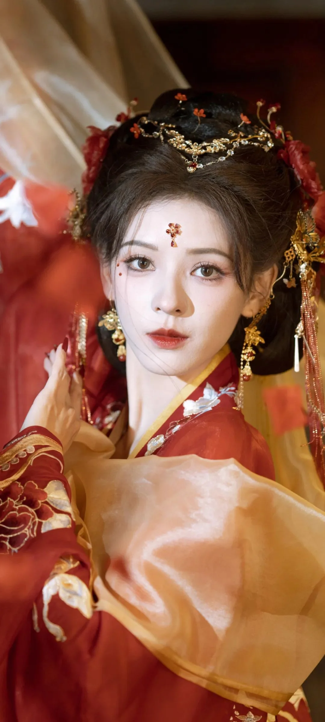 一位身穿红色传统服饰、佩戴华丽头饰的女性人物占据画面主体。