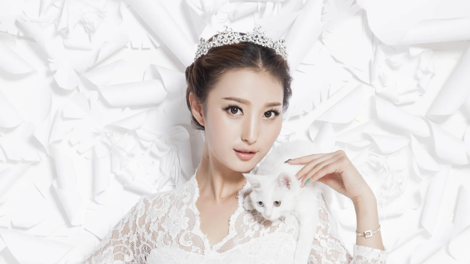 一名戴着 tiara 的女子穿着白色蕾丝服饰，怀抱一只白猫，背景为白色褶皱纹理。