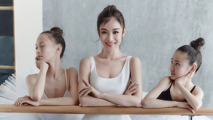 三名成年女性在室内靠着木桌摆姿势。