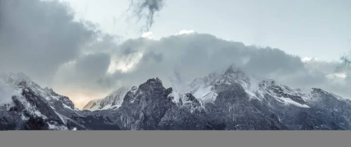 覆雪的群山在厚重云层下延展开来。