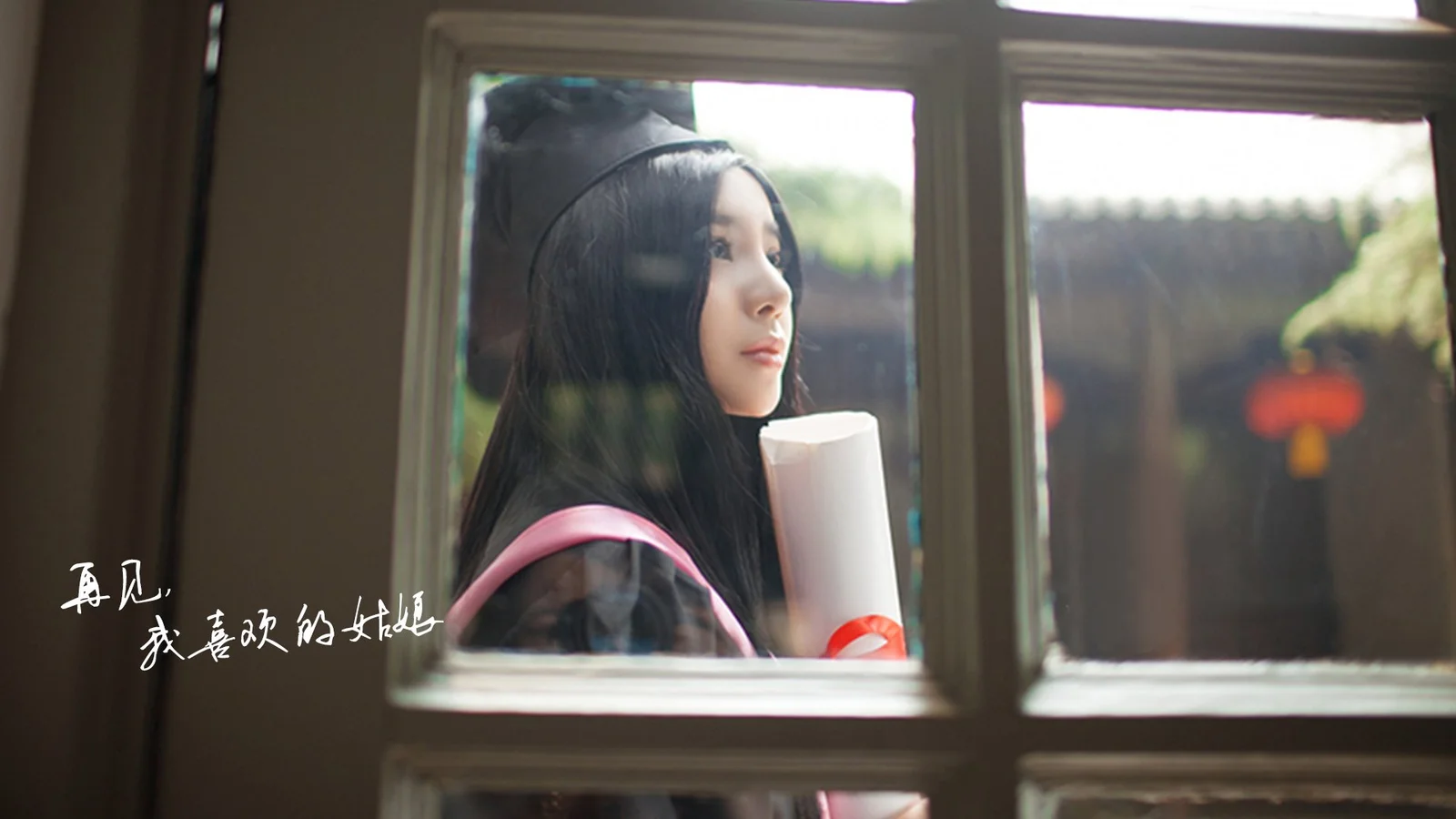一名黑发女子站在窗边，透过玻璃望向窗外。