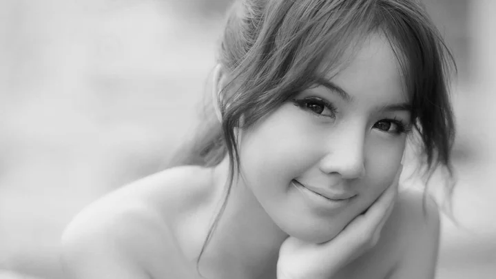 一位成年女性以黑白肖像形式微笑注视镜头。