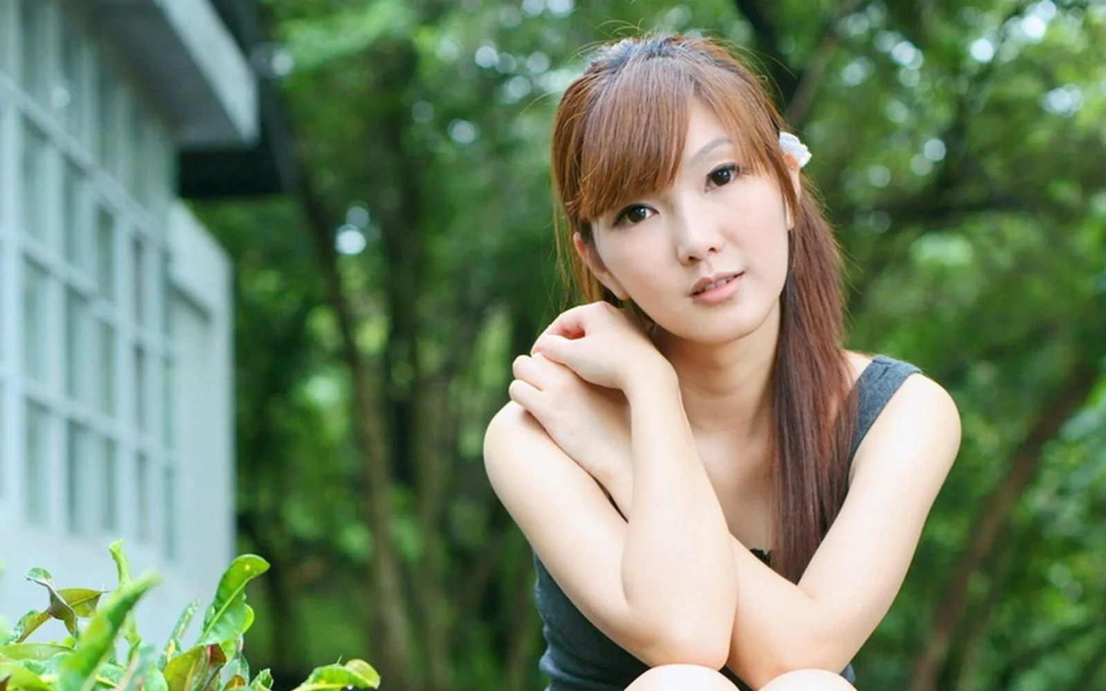 一名成年女性在绿意环绕的户外环境中面对镜头。