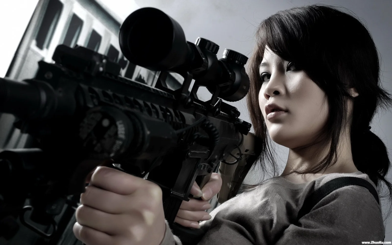 一名女性近距离手持带瞄准镜的步枪，画面以深色背景和冷色调为主。