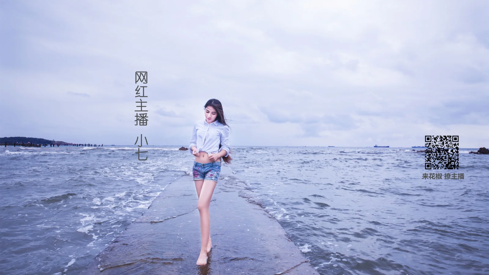 一名女性走在海边延伸入海的浅色堤道上，周围是海水与阴云天空。