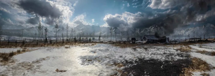 积雪覆盖的旷野延伸至远处的山脉，乌云与阳光交织在天空中，前景可见木栅栏和小屋。