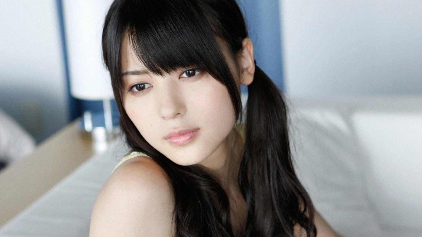 室内で撮影された長い黒髪の女性のクローズアップポートレート。