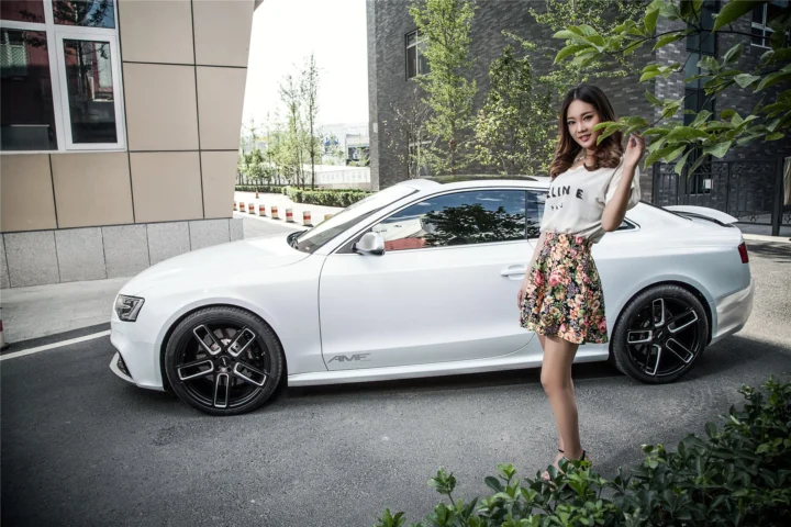 一名女性站在现代白色轿车旁的户外场景中。
