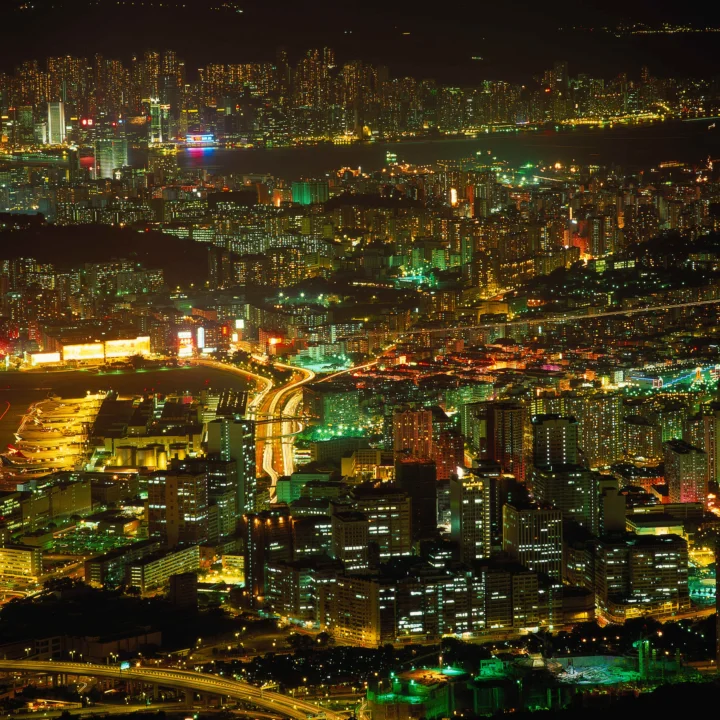 夜色中的密集城市建筑、灯光、道路与水面构成璀璨的都市夜景。