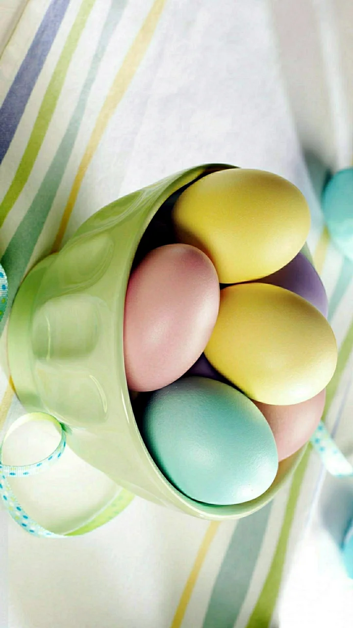 多个柔和色彩的椭圆形物体排列在绿色半透明容器中，背景带有浅色条纹。