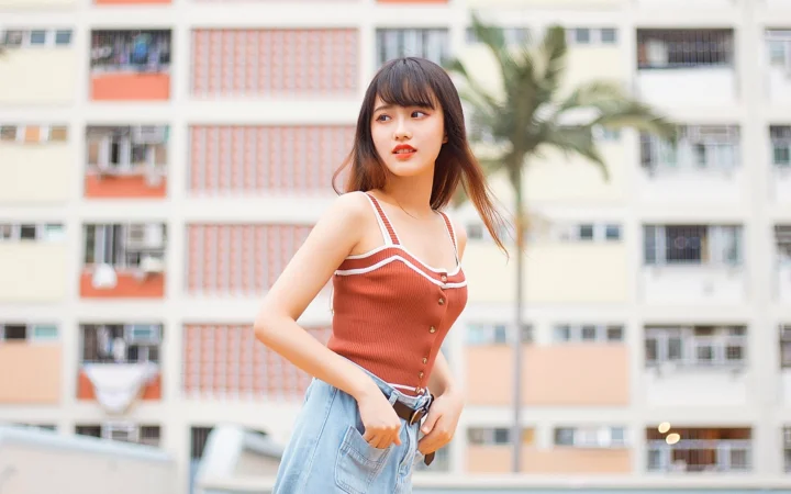 一名女性站在公寓楼前的户外人像照片。