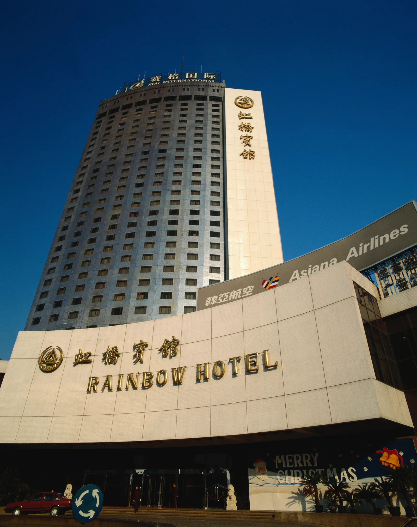 一座高耸的城市酒店建筑在晴朗的深蓝色天空下向上延伸。