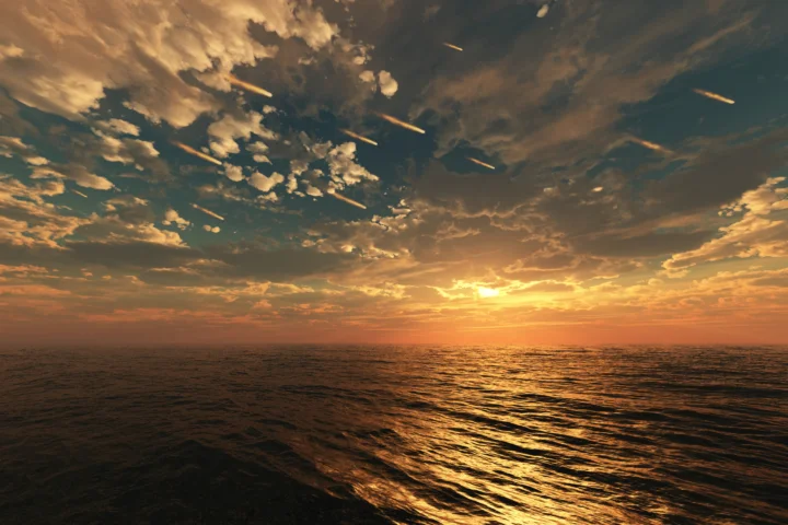 夕阳照耀着波光粼粼的海面，天空布满层叠的金色云彩。