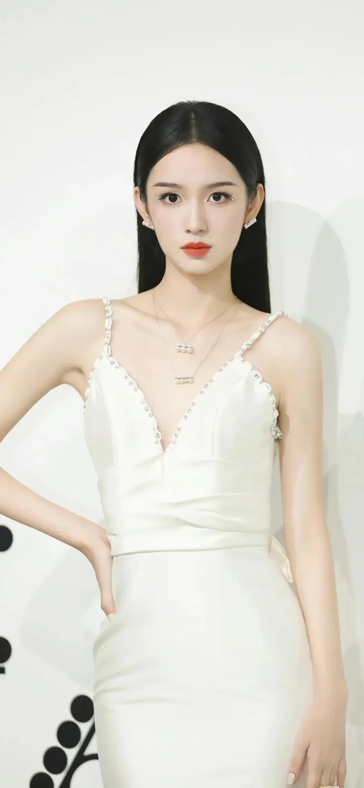 흰색 드레스를 입은 여성이 밝은 배경 앞에 서 있습니다.