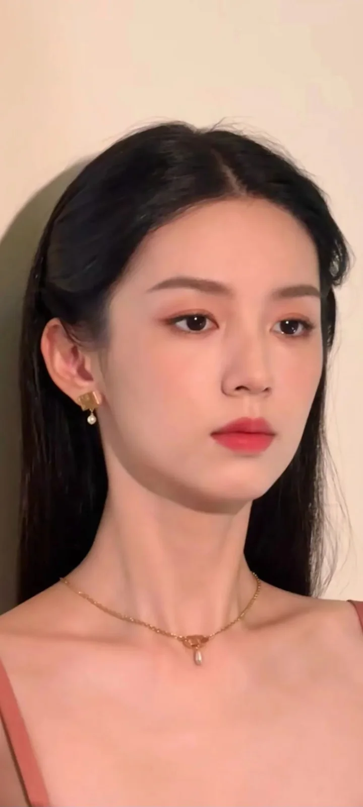 一名黑发女性在米色背景前的近距离肖像。