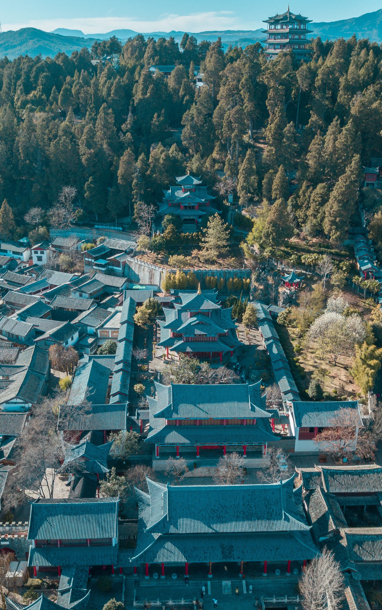俯瞰山林中的传统建筑群，远处可见层叠山峦。