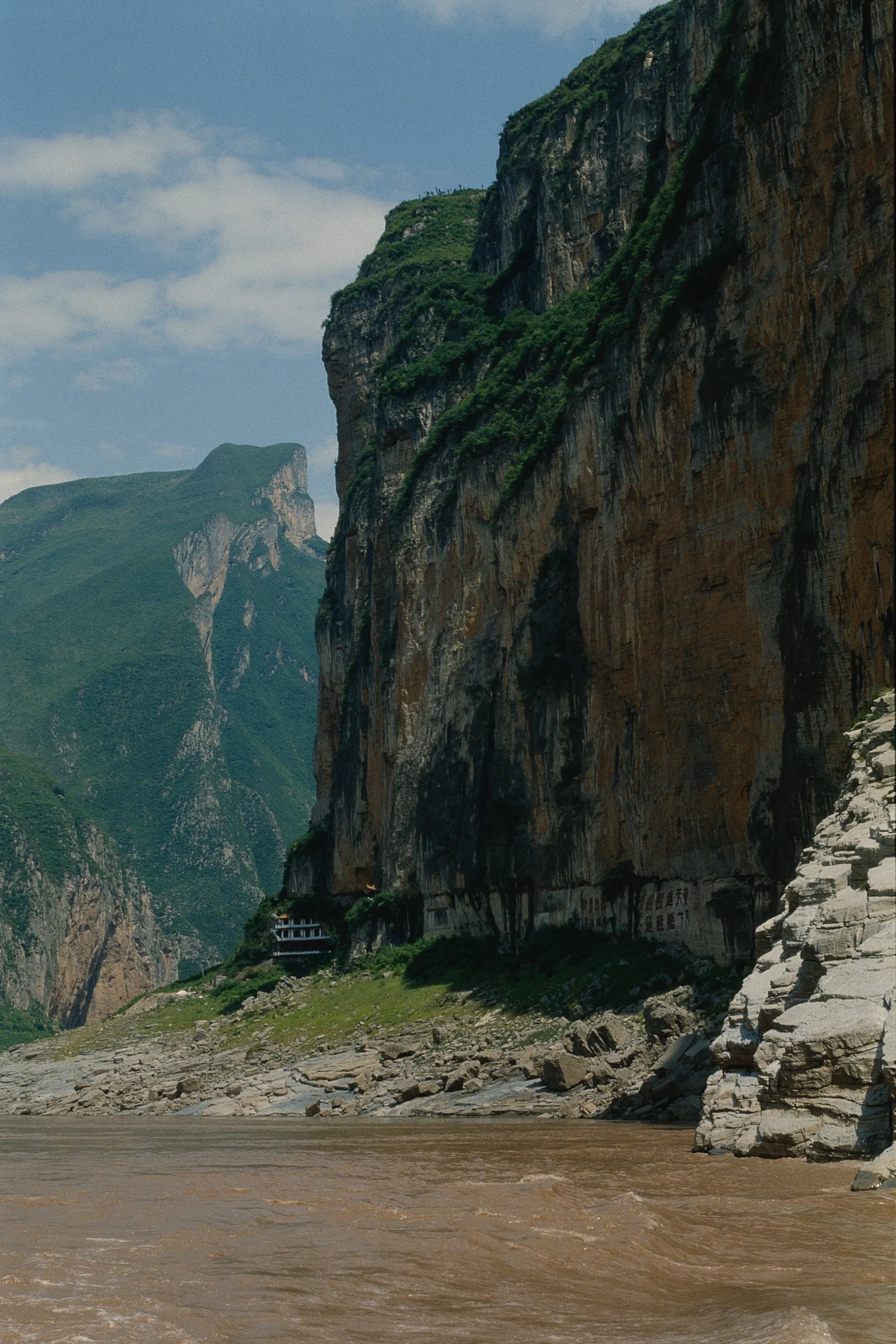 高耸的岩壁、远处的山峰与谷底河流构成壮丽的峡谷风景。