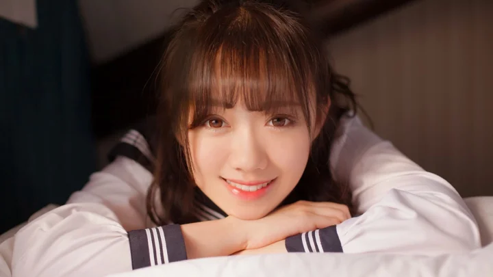 一位棕色长发女子将手臂交叠在身前，面带微笑看向镜头。