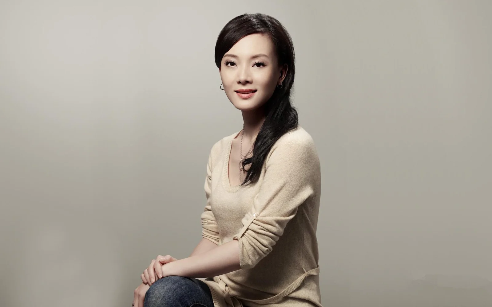중성적인 배경 앞에서 성인 여성을 촬영한 스튜디오 인물 사진입니다.