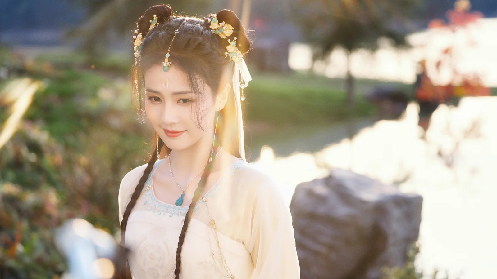 一位身穿浅色汉服的女子站在户外光影中。