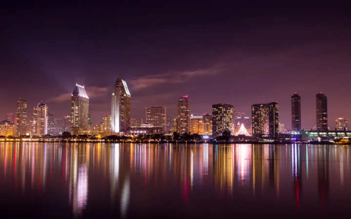 夜色中的城市天际线倒映在平静的水面上，建筑灯光与霓虹交相辉映。