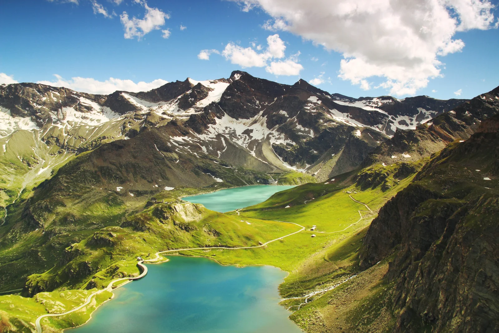 陽光下的雪山、翠綠山谷與兩座碧藍湖泊構成壯麗的自然風景。