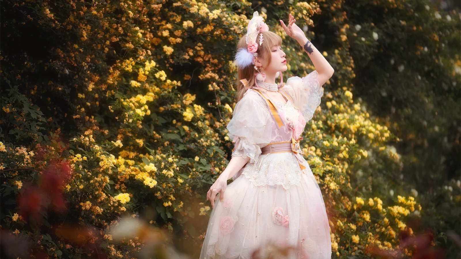 白いドレスを着た女性が、花の咲き誇る庭に立っている。