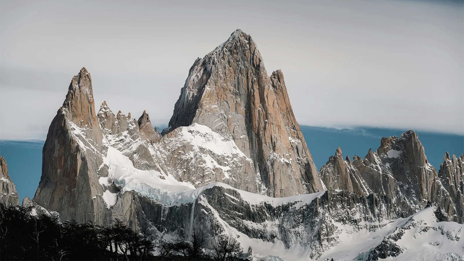 巍峨尖峭的雪山與冰川在陰雲天空下構成壯麗的自然景觀。